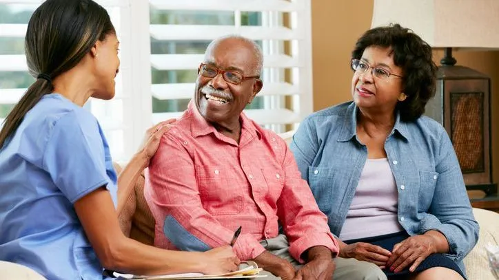 A nurse meets with a senior couple in their home. 