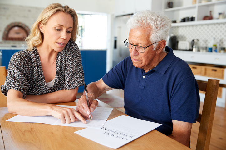 A father filling out retirement documents with his daughter.